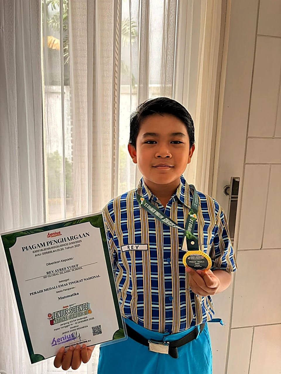 Rey Ayres Yusuf holding his gold medal and the Jenius Science National Olympiad 2.0 Mathematics certificate